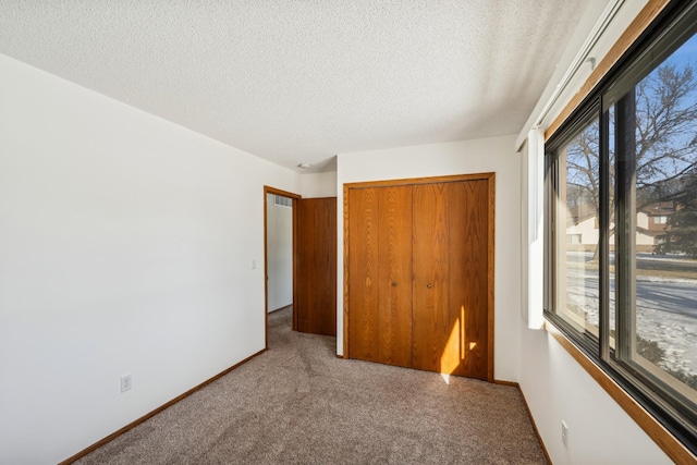 unfurnished bedroom with a closet, a textured ceiling, and carpet