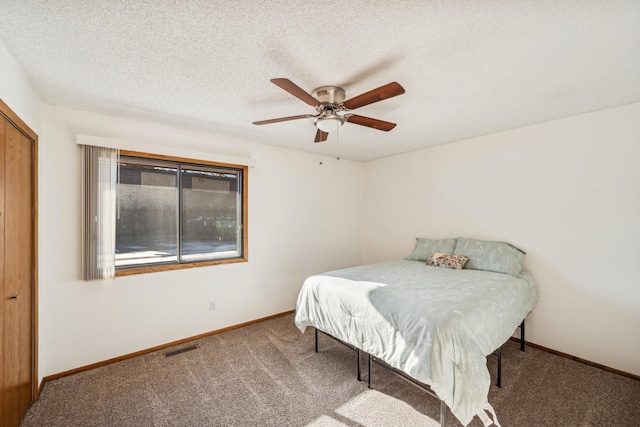 carpeted bedroom with a textured ceiling and ceiling fan