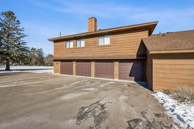 view of snowy exterior featuring a garage