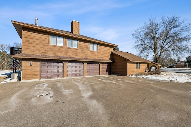 view of side of property featuring a garage and central AC