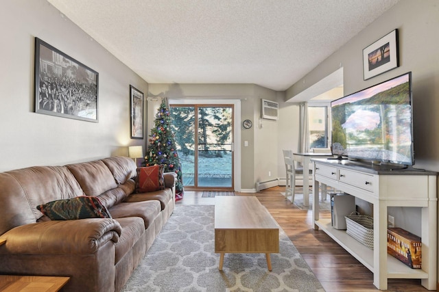 living room featuring hardwood / wood-style flooring, a baseboard radiator, a wall mounted AC, and a textured ceiling