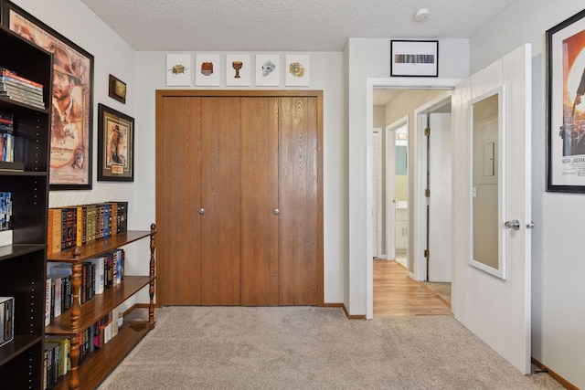 bedroom featuring a closet, light carpet, and a textured ceiling