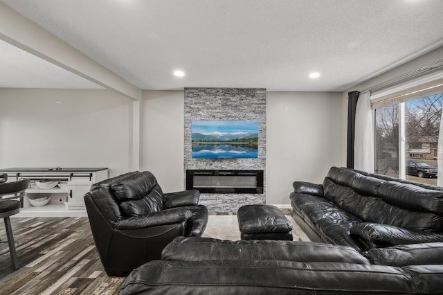 living room featuring a fireplace, a textured ceiling, and dark hardwood / wood-style floors