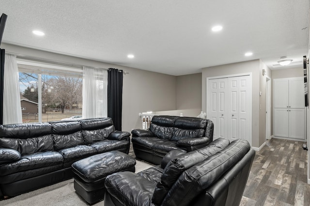 living room with dark hardwood / wood-style flooring and a textured ceiling