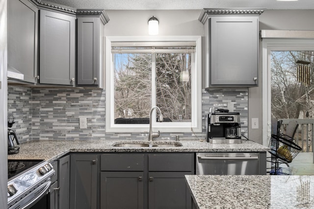 kitchen with backsplash, gray cabinetry, sink, and stainless steel appliances