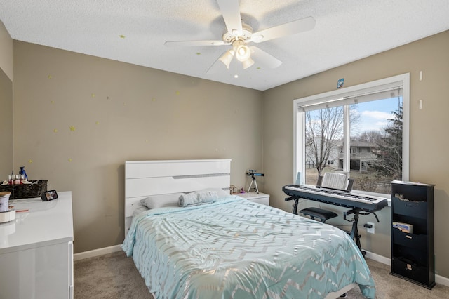 carpeted bedroom with ceiling fan and a textured ceiling