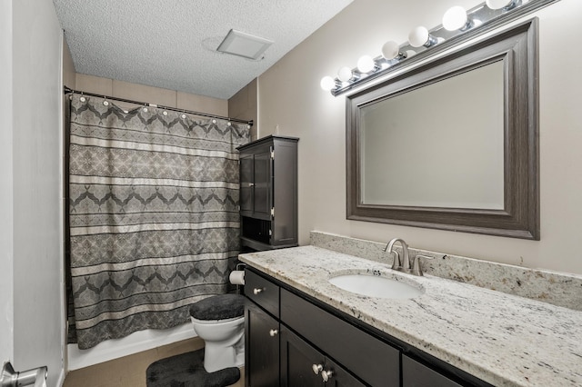 bathroom featuring a shower with shower curtain, tile patterned floors, vanity, a textured ceiling, and toilet