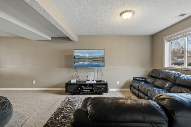 carpeted living room featuring beamed ceiling and a textured ceiling