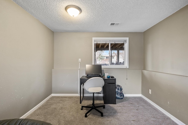 carpeted office space with a textured ceiling