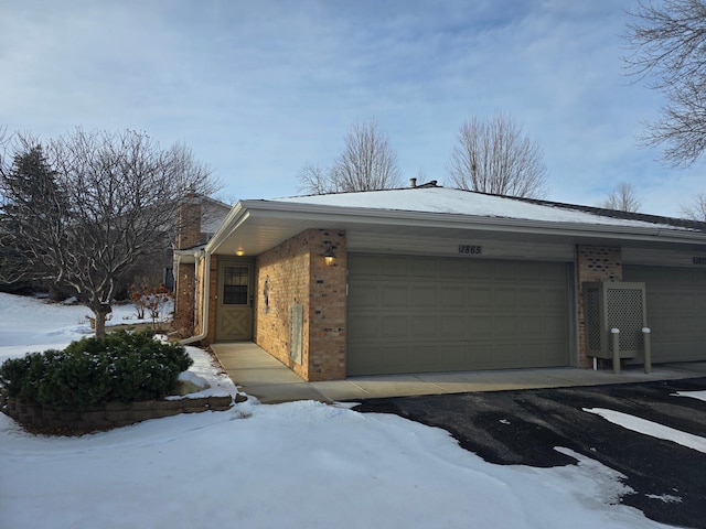 snow covered property with a garage