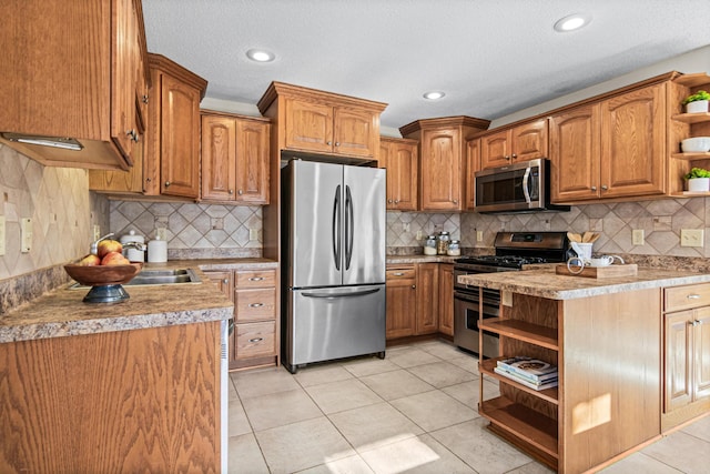 kitchen with light tile patterned floors, backsplash, and appliances with stainless steel finishes