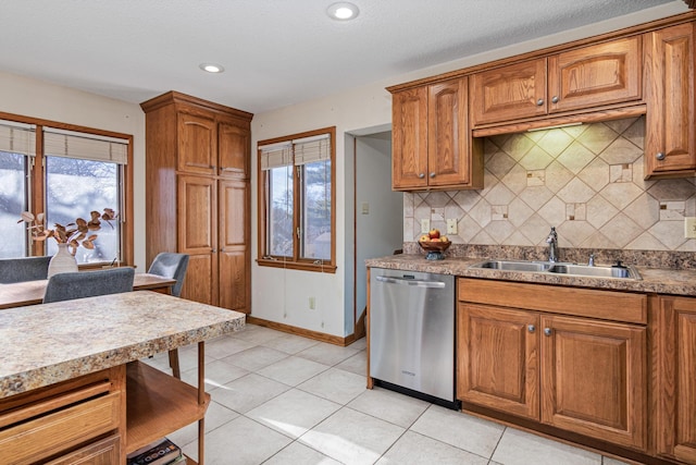 kitchen featuring light tile patterned flooring, sink, a textured ceiling, stainless steel dishwasher, and backsplash