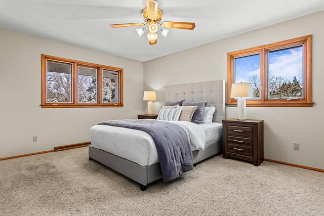 bedroom featuring light carpet, multiple windows, and ceiling fan