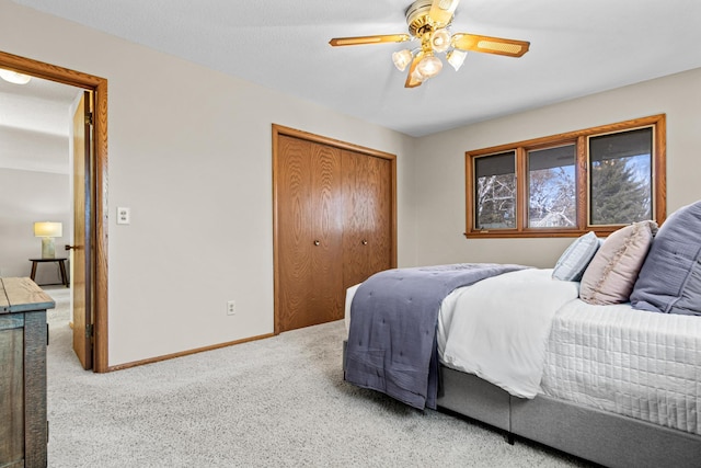 carpeted bedroom featuring ceiling fan and a closet