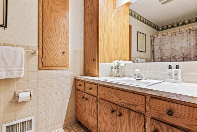 bathroom featuring vanity and tile walls