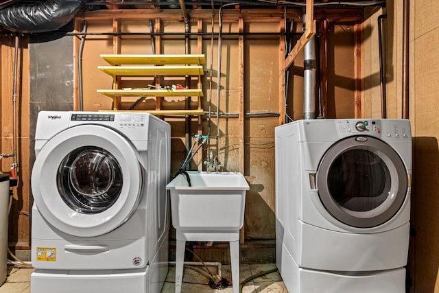 clothes washing area featuring washing machine and clothes dryer and sink