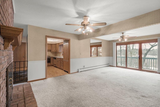 unfurnished living room with ceiling fan, sink, a brick fireplace, a baseboard heating unit, and light colored carpet