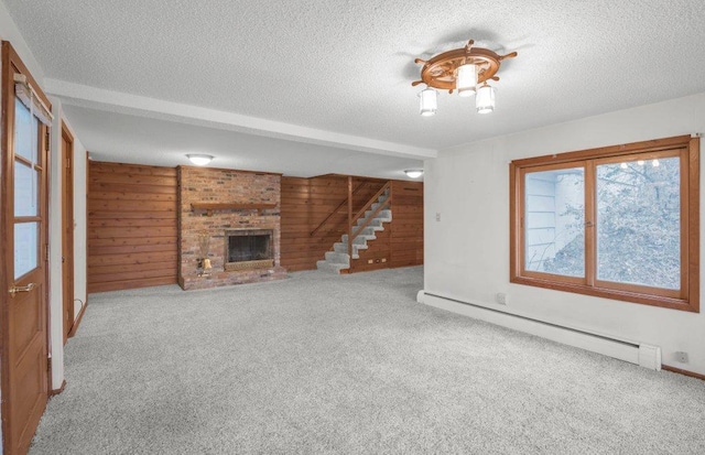 unfurnished living room with light colored carpet, baseboard heating, wooden walls, and a brick fireplace