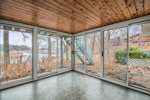 unfurnished sunroom featuring a healthy amount of sunlight and wood ceiling