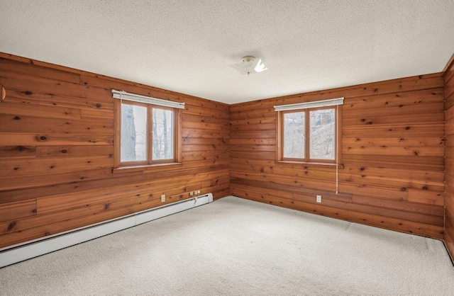 unfurnished room featuring carpet flooring, plenty of natural light, and a baseboard radiator