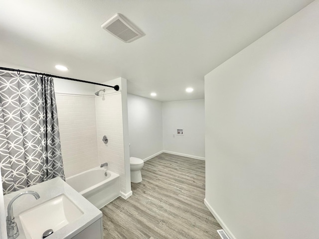 full bathroom with hardwood / wood-style floors, toilet, shower / bathtub combination with curtain, and sink