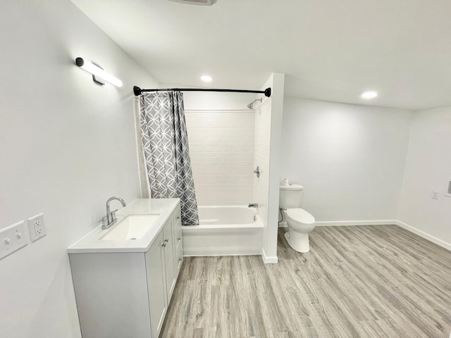 full bathroom with hardwood / wood-style floors, vanity, shower / tub combo, and toilet