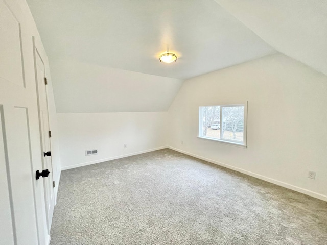 additional living space with carpet floors and vaulted ceiling