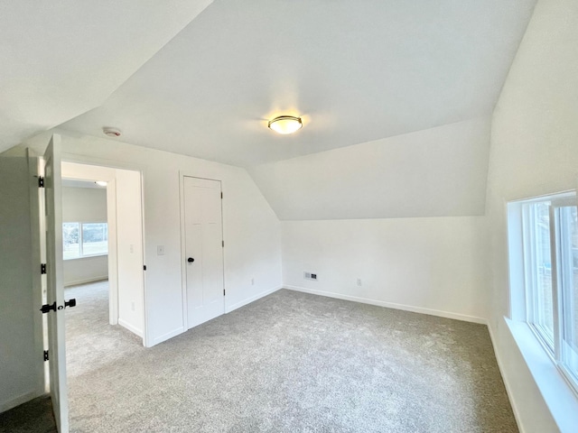 bonus room featuring light colored carpet and vaulted ceiling