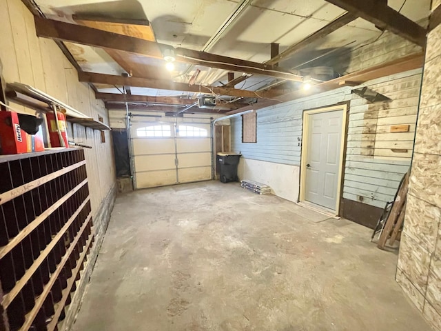 garage with wood walls and a garage door opener