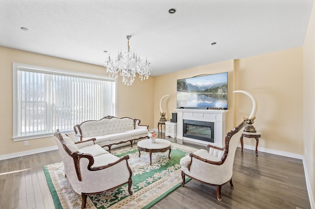 living room featuring a textured ceiling, a chandelier, and hardwood / wood-style flooring