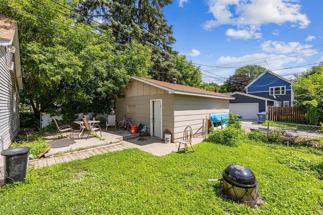 exterior space featuring a yard, an outdoor structure, an outdoor fire pit, and a patio