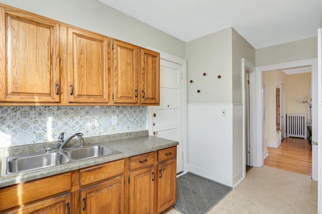 kitchen featuring backsplash, radiator, and sink