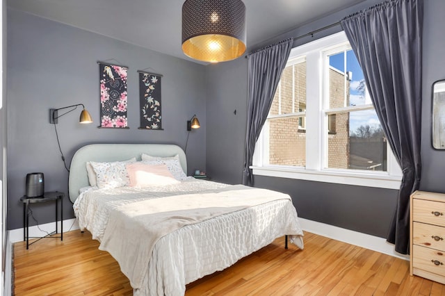 bedroom with hardwood / wood-style flooring and multiple windows