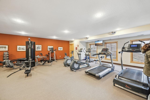 exercise room featuring carpet floors and a textured ceiling