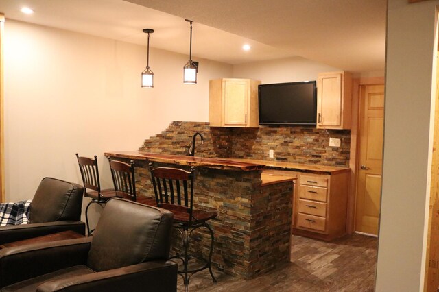 bar featuring pendant lighting, light brown cabinets, dark hardwood / wood-style flooring, and tasteful backsplash