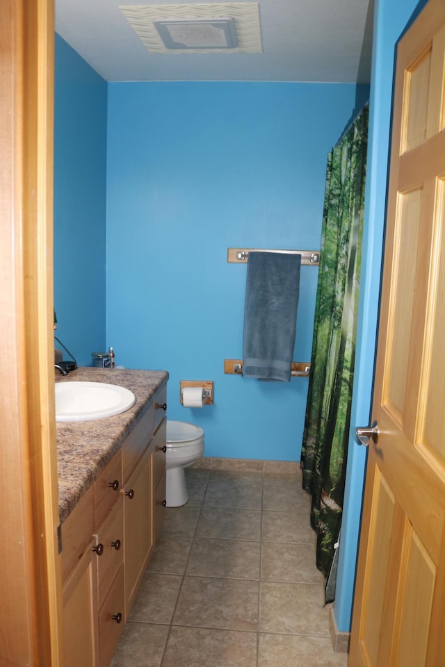 bathroom featuring toilet, vanity, and tile patterned floors