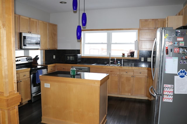 kitchen featuring stainless steel appliances, sink, pendant lighting, a center island, and dark hardwood / wood-style floors