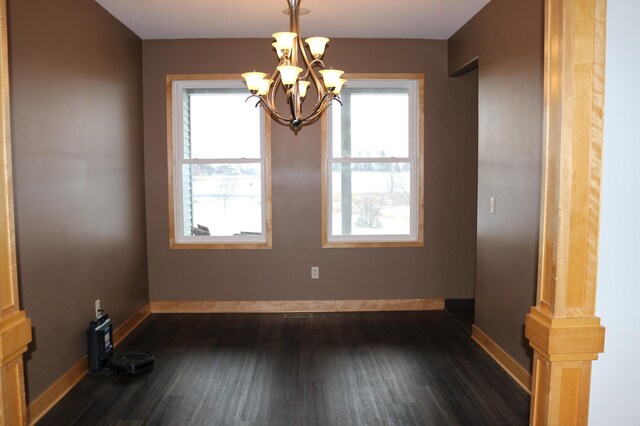 unfurnished room with dark hardwood / wood-style flooring and a chandelier