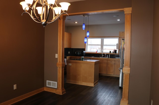 kitchen with sink, dark hardwood / wood-style floors, stainless steel fridge, decorative light fixtures, and light brown cabinetry