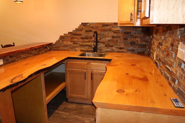 kitchen featuring wood counters, decorative backsplash, dark wood-type flooring, and sink