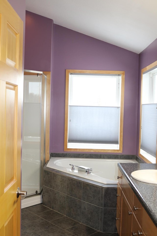 bathroom with tile patterned floors, vanity, and shower with separate bathtub