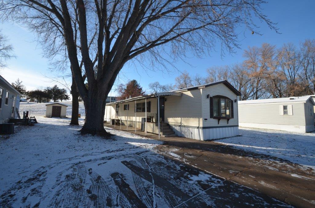 snow covered property with an outdoor structure and central AC