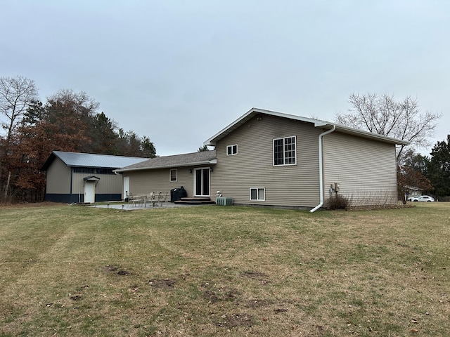 rear view of property with a lawn, a patio, and central AC unit