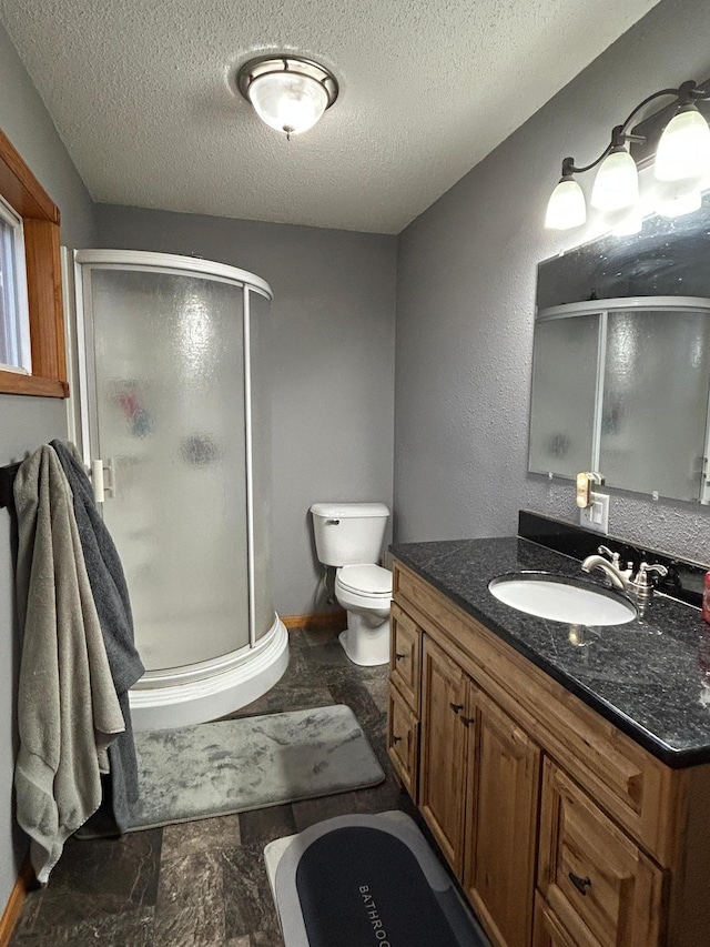 bathroom with vanity, a textured ceiling, toilet, and an enclosed shower