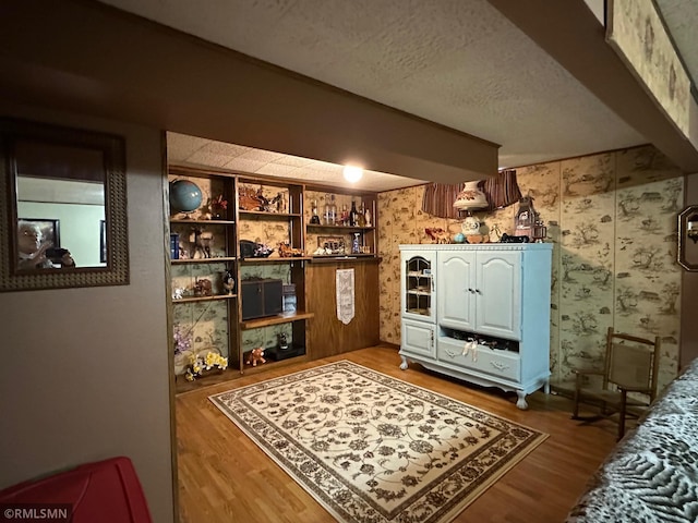 interior space featuring built in features, wood-type flooring, and a textured ceiling