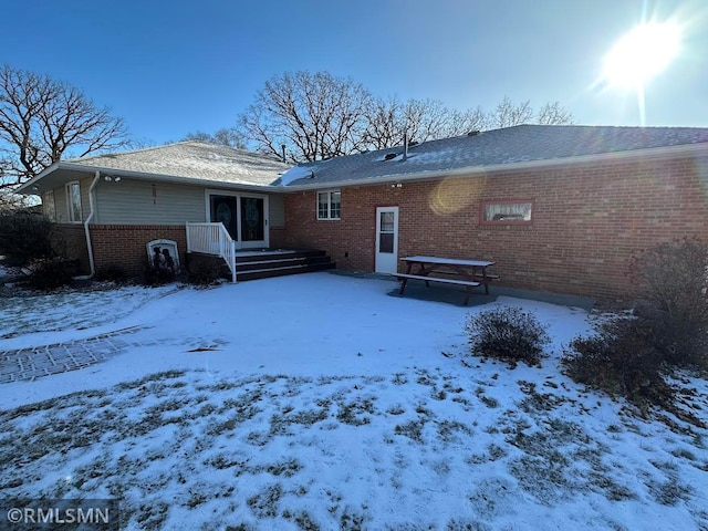 view of snow covered rear of property