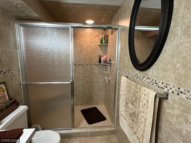 bathroom with a shower stall, toilet, vanity, and tile patterned floors
