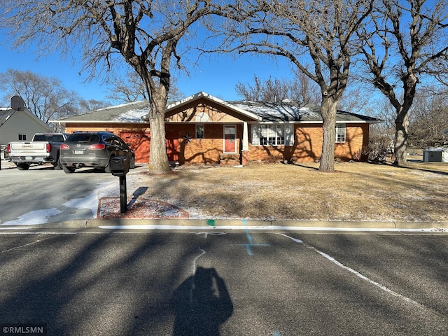 ranch-style house with concrete driveway and brick siding