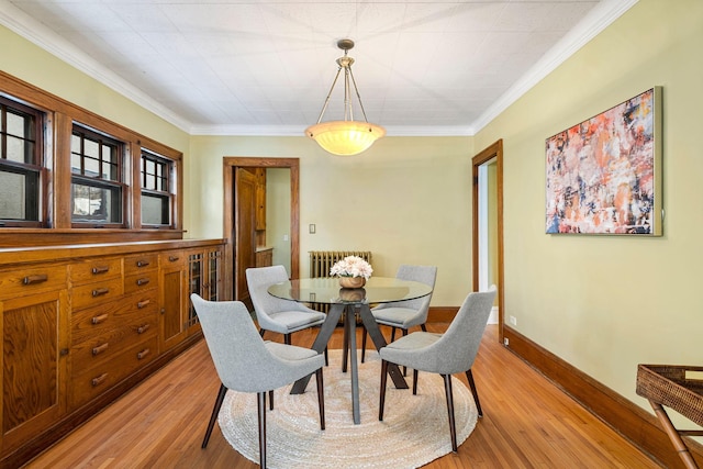 dining area featuring radiator heating unit, light hardwood / wood-style floors, and ornamental molding