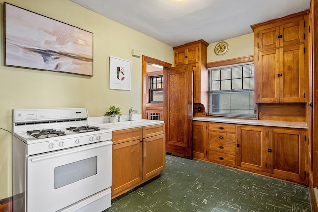 kitchen with white gas range and sink